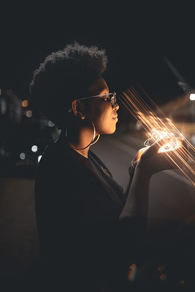 Person wearing glasses and holding fairy lights