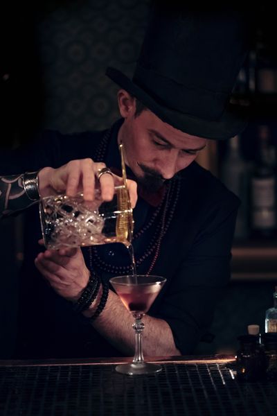 Person making a drink at a bar